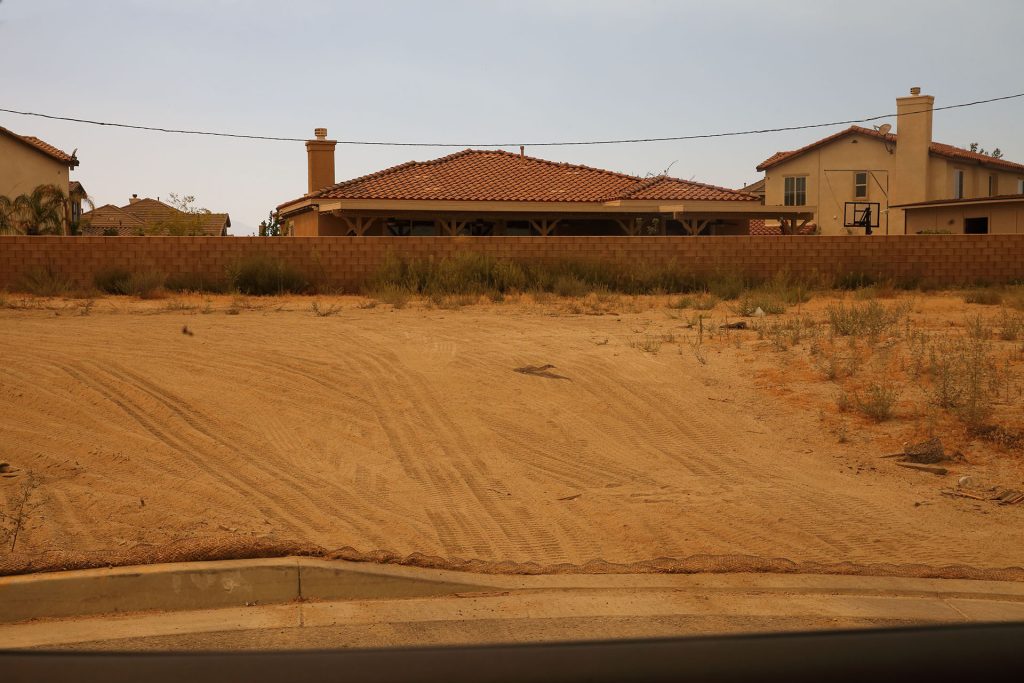 Dirt hill with houses in distance