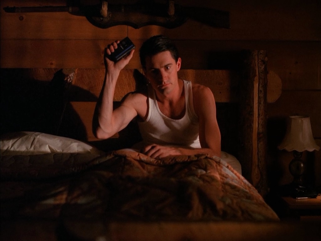 Dale Cooper in bed holding up his tape recorder