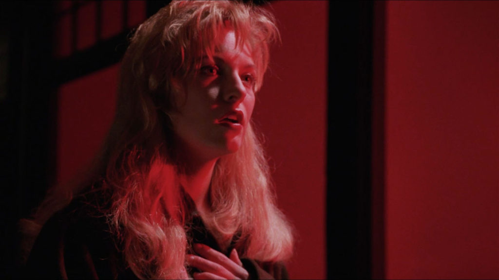 Laura Palmer looking on while touching her chest