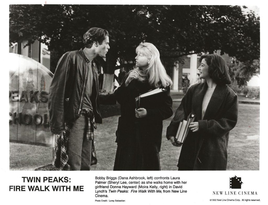 Black and white production still of Bobby Briggs (Dana Ashbrook), Laura Palmer (Sheryl Lee) and Donna Hayward (Moira Kelly) in the courtyard of Twin Peaks High School from Twin Peaks: Fire Walk With Me