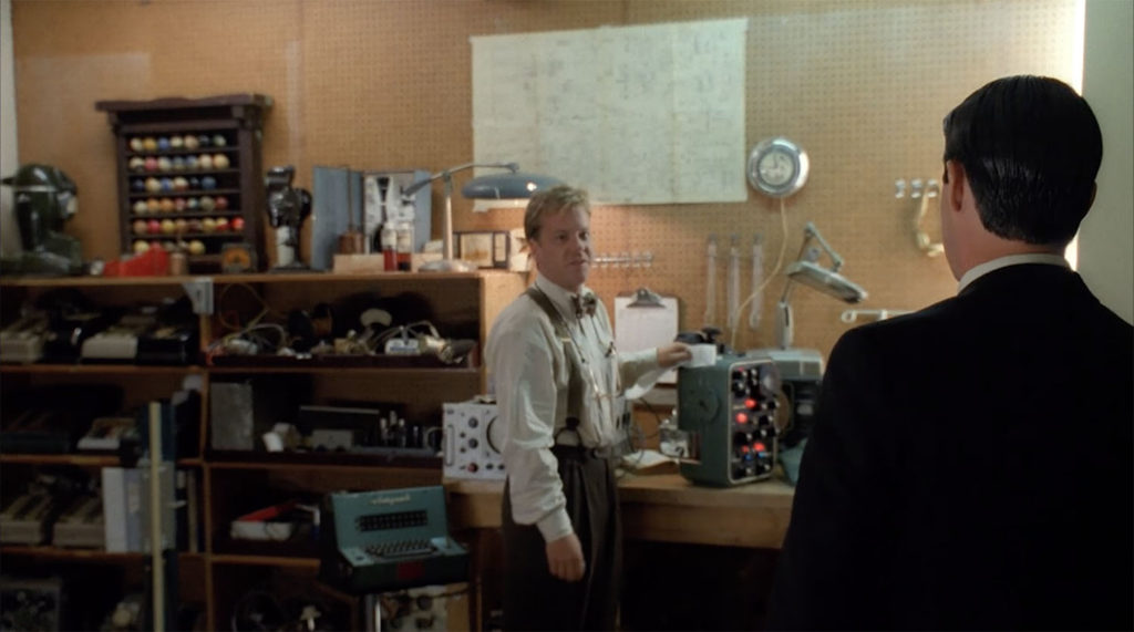 Agent Sam Stanley is his work shop showing off his Whiteman machine to Special Agent Cooper