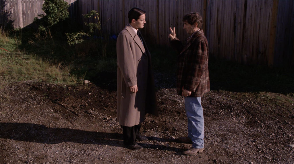 Agent Cooper (Kyle MacLachlan) and Carl Rodd (Harry Dean Station) at the Fat Trout Trailer Park. Rodd is holding up two fingers.