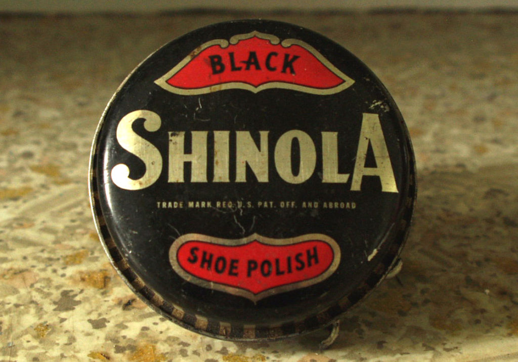 A black tin with gold lettering Shinola