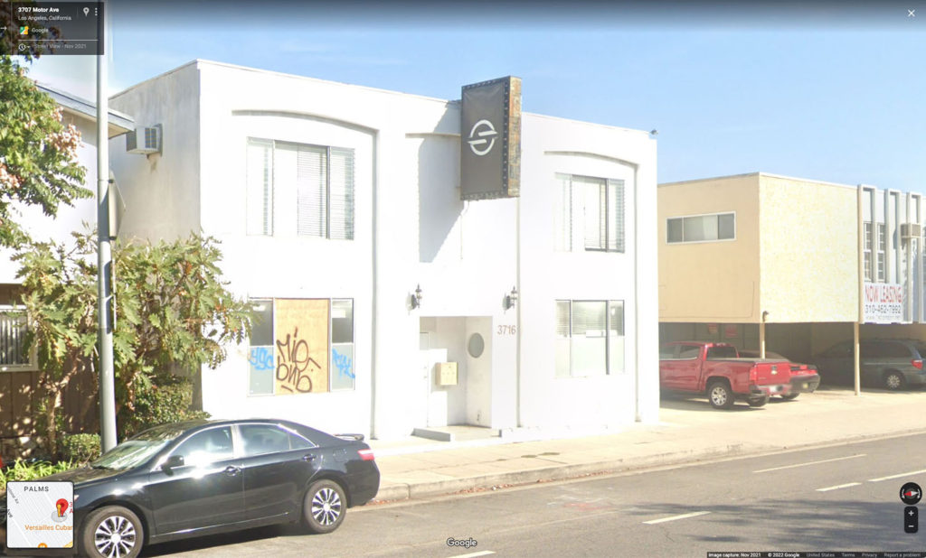 Google Street View image of a white building along a street