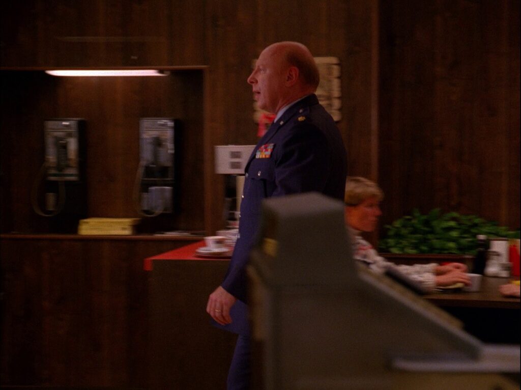 Major Briggs walking toward the exit of the Double R Diner