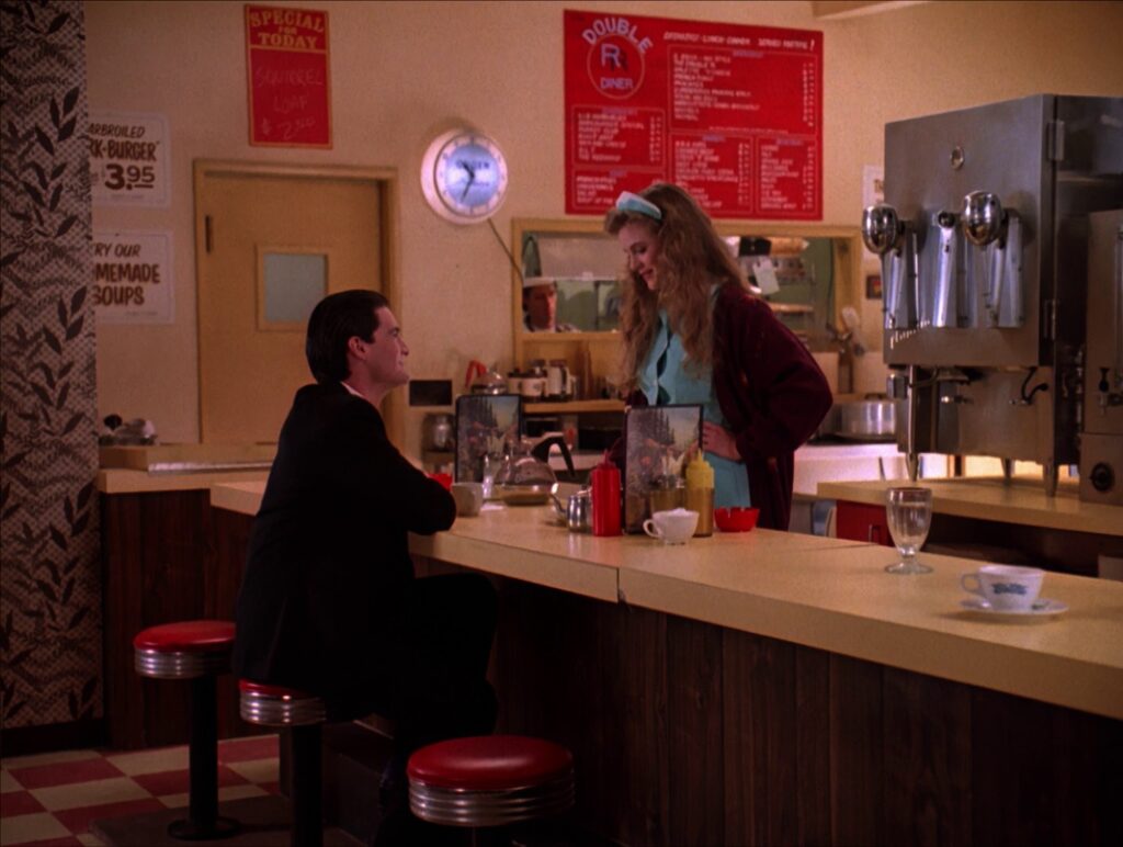 Agent Cooper sitting at the counter while Annie stands behind the counter at the Double R Diner