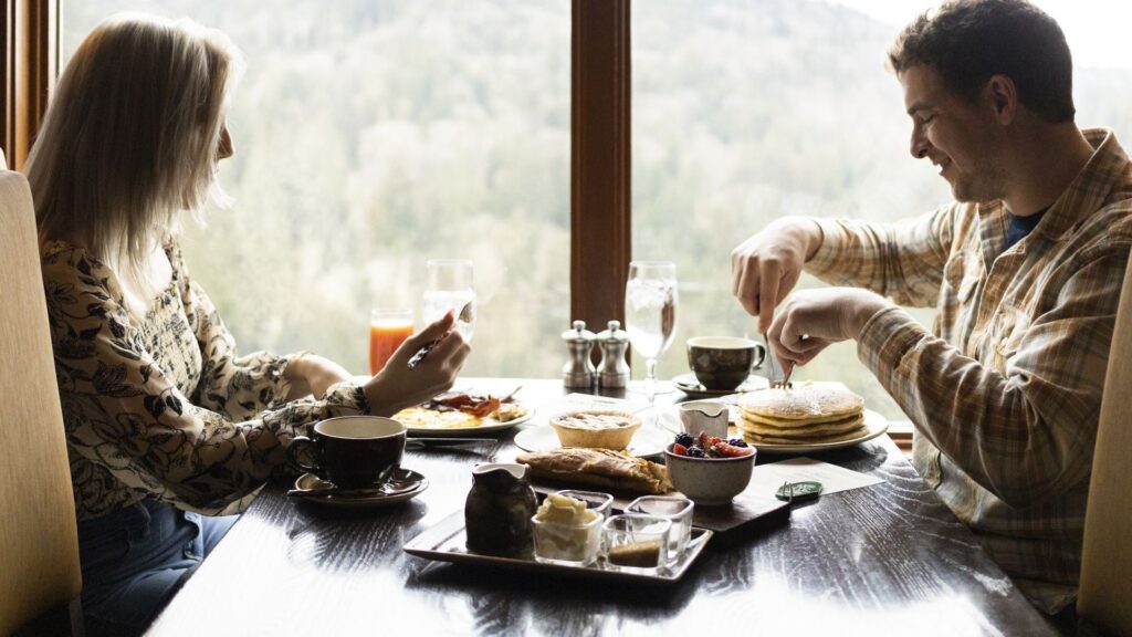 Couple enjoying breakfast by a window in the Dining Room at The Salish Lodge.