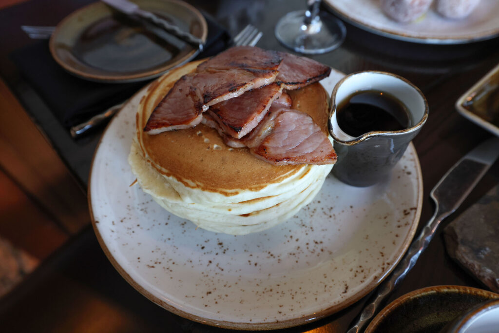 Short stack of griddle cakes, ham and maple syrup