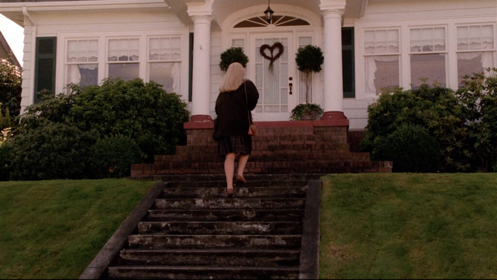 Laura Palmer walking up stairs to a white home.