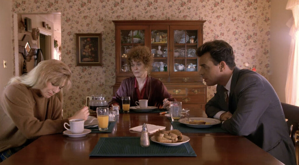 Three people having breakfast at a table. Laura Palmer starts to cry when Leland asks to speak with her.