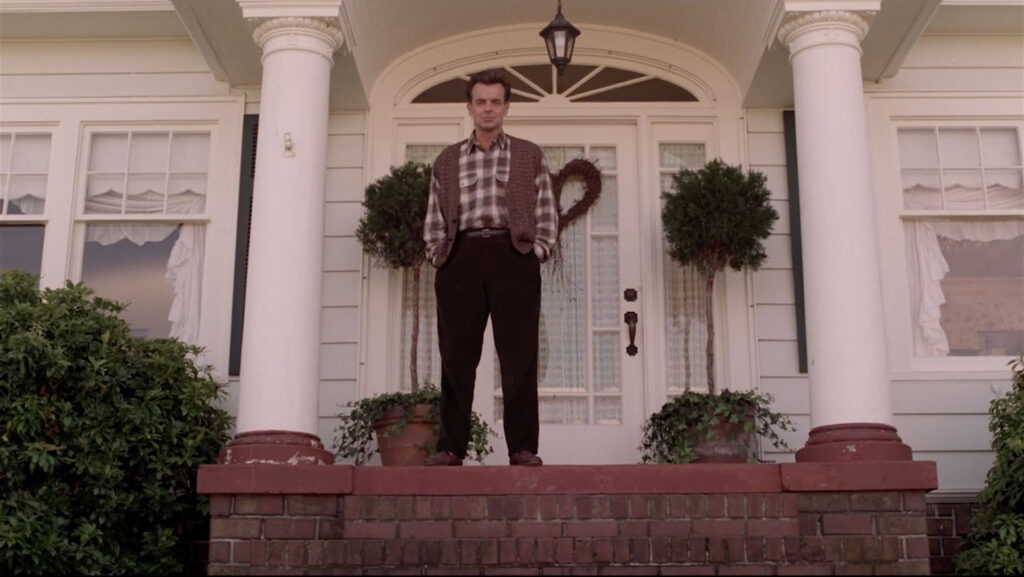 Leland Palmer standing on the front steps of his house