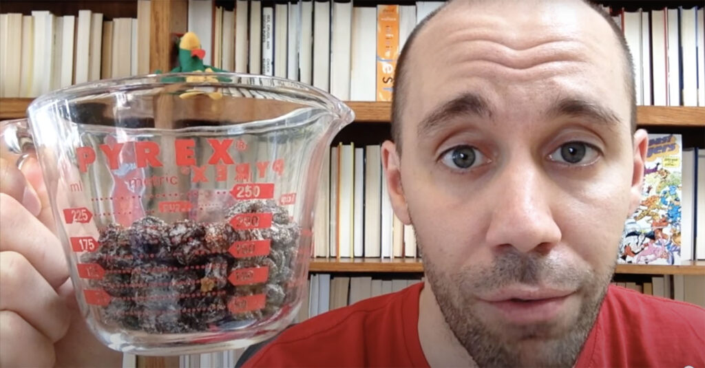 Man holding a Pyrex measuring cup with raisins.