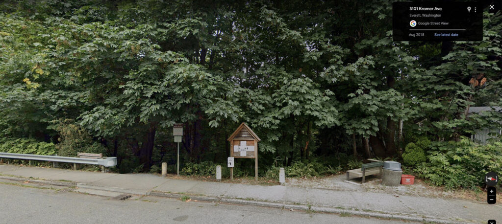 Google Street View image of a trail entrance with trees