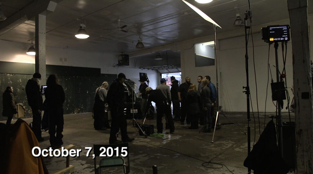 A film crew gathered in a garage