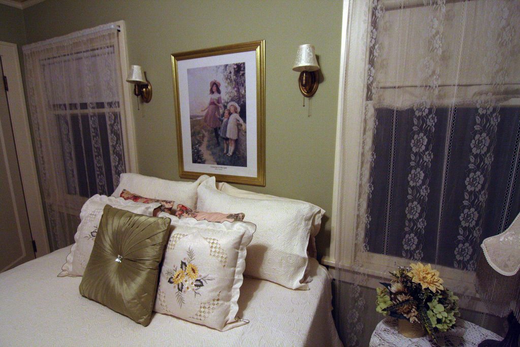 Bedroom with a bed and two windows with curtains