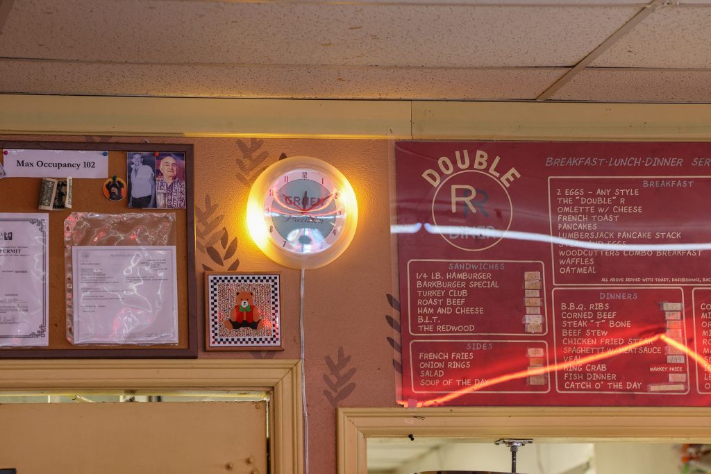 Twede's Cafe wall with a clock, bear plaque and Double R Diner menu