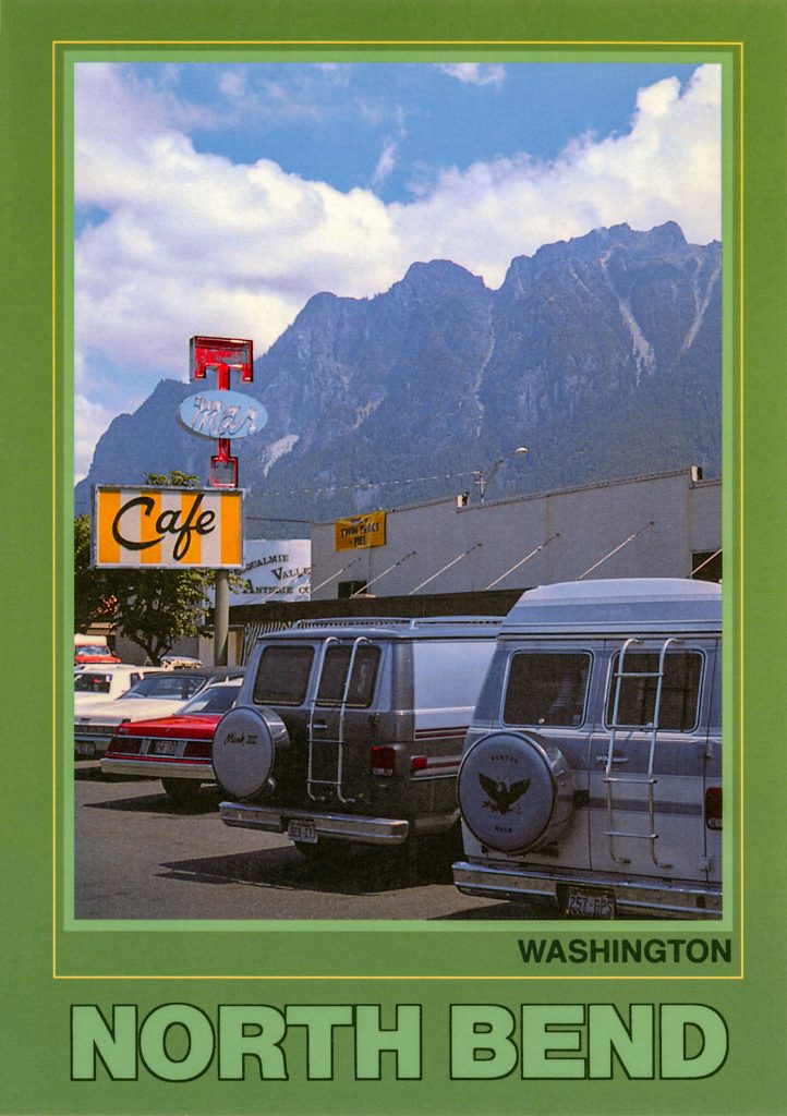 Postcard with green boarder and image of Mar-T Cafe with vans parked in the parking lot. Mount Si is seen in the distance