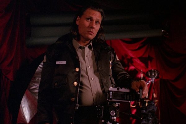 Deputy Hawk standing next to a camera in a cabin
