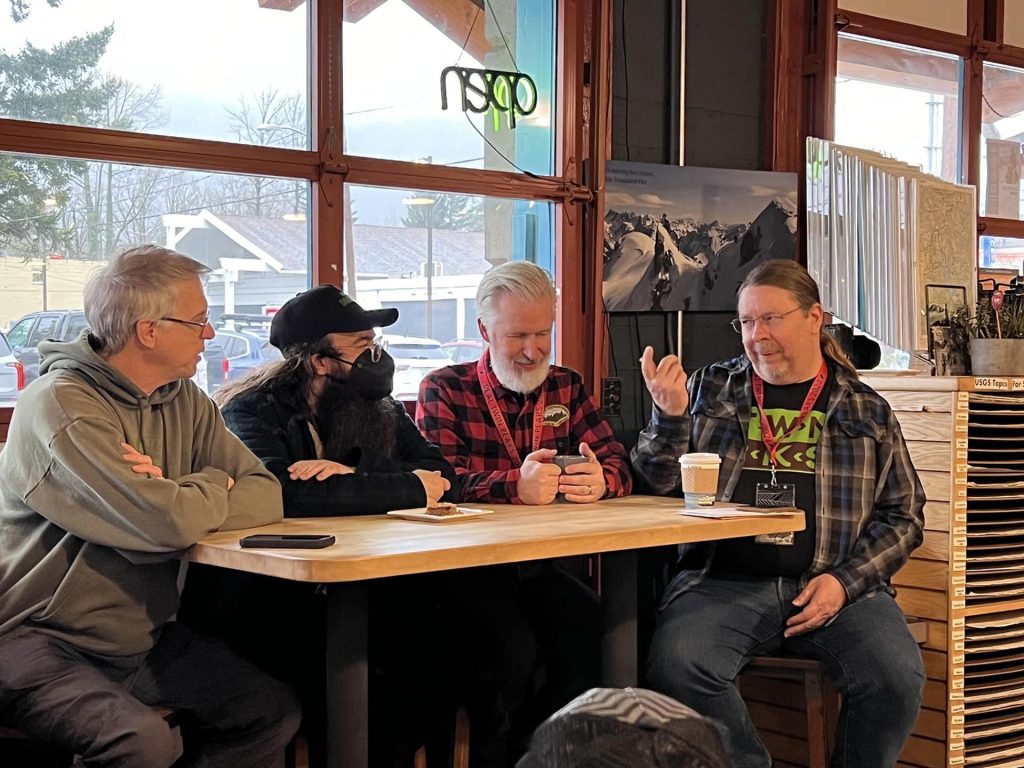 Four people talking a table in a coffee house
