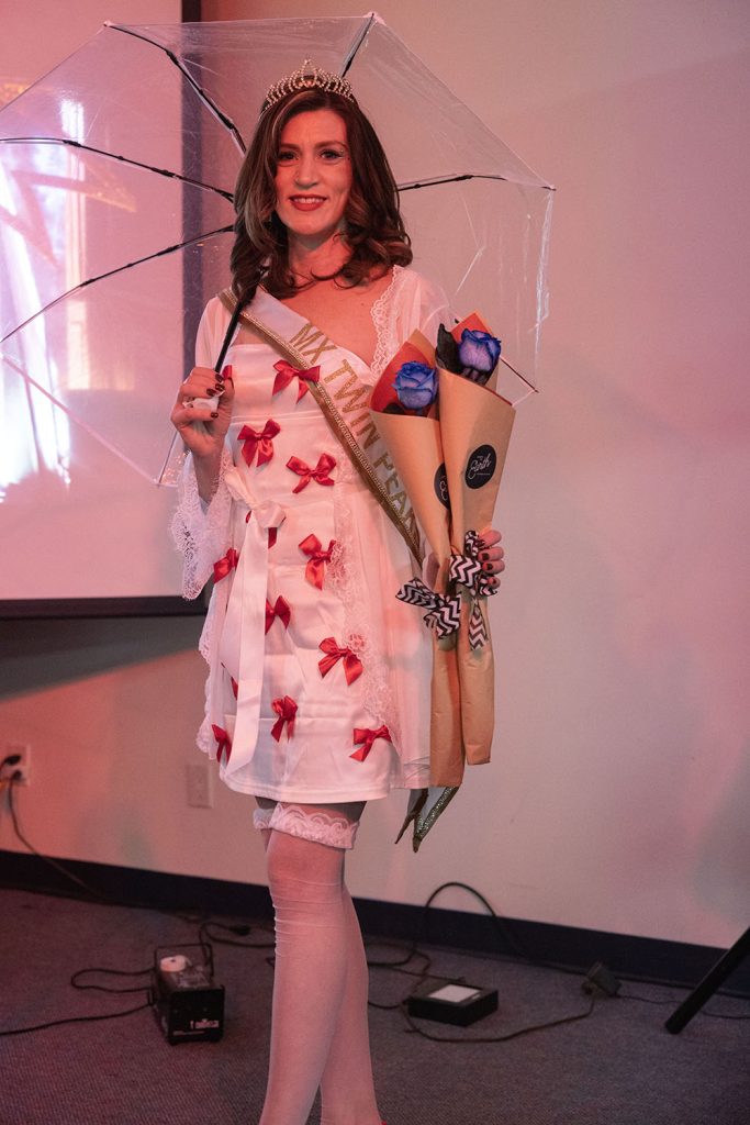 Woman dressed as Audrey Horne holding an umbrella and blue roses