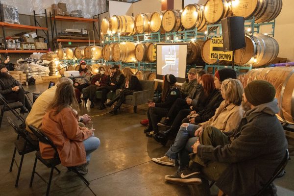 People gathered in an event space with beer barrels