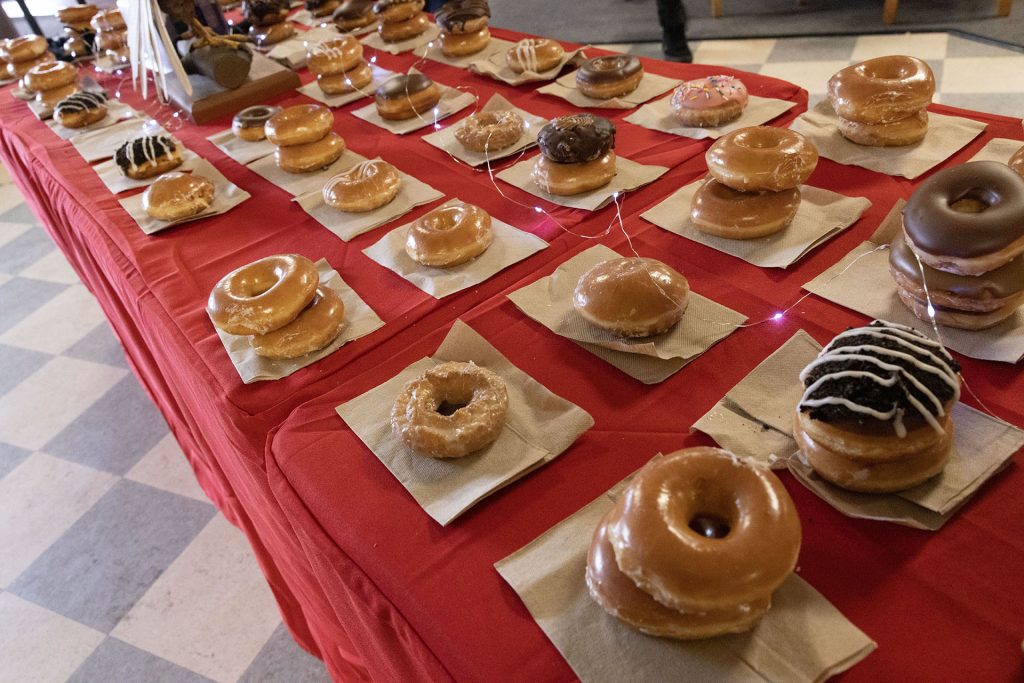 Doughnuts stacked on a red-skirted table