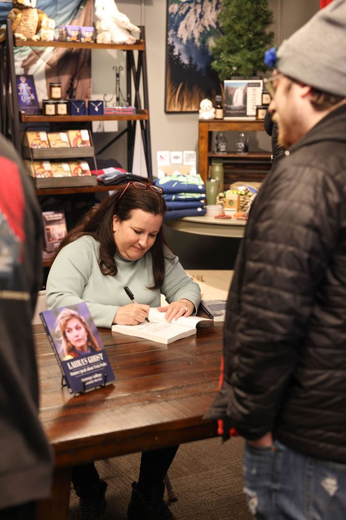 Courtenay signing a book