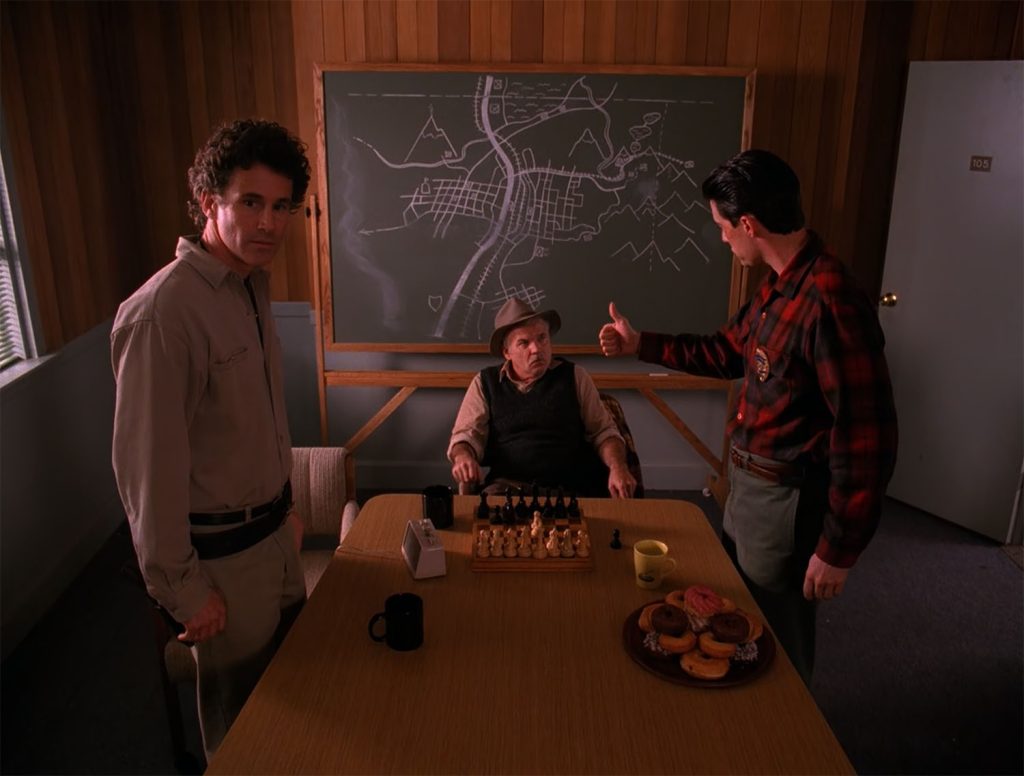 Twin Peaks Sheriff's Department with Pete Martell sitting at a table with Sheriff Truman and Agent Cooper standing