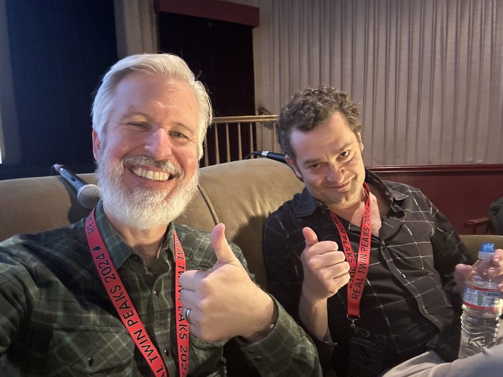 Steven and Josh Eisenstadt sitting on a couch and giving a thumbs up