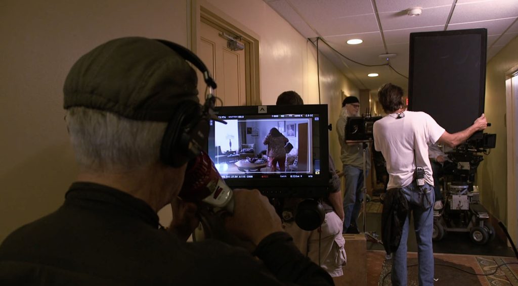 David Lynch directing crew in apartment hallway