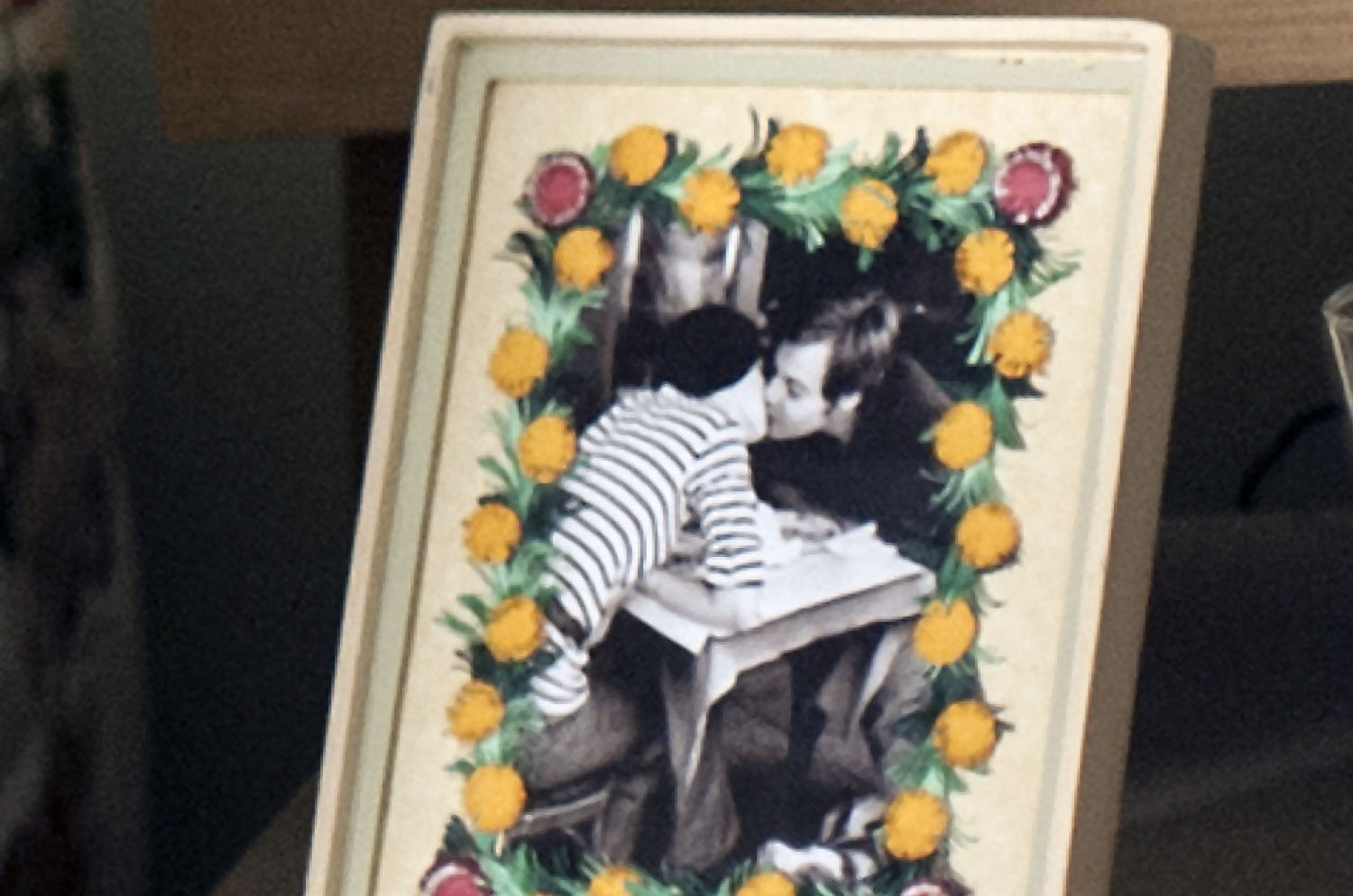 Frame with floral border and black and white image of people kissing