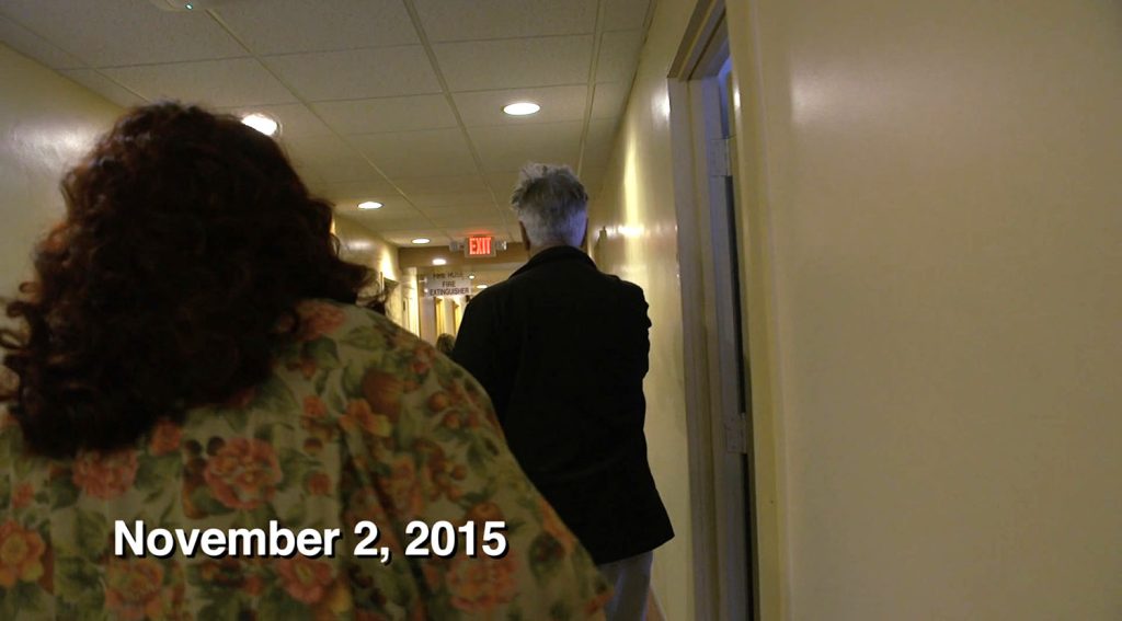 Melissa Bailey and David Lynch walking down a hall