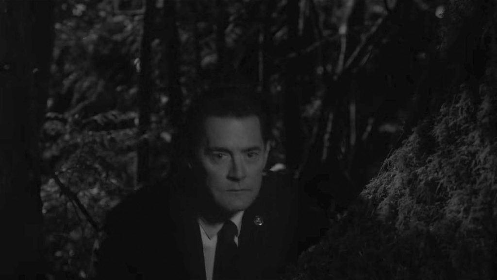 Agent Cooper hiding behind a tree