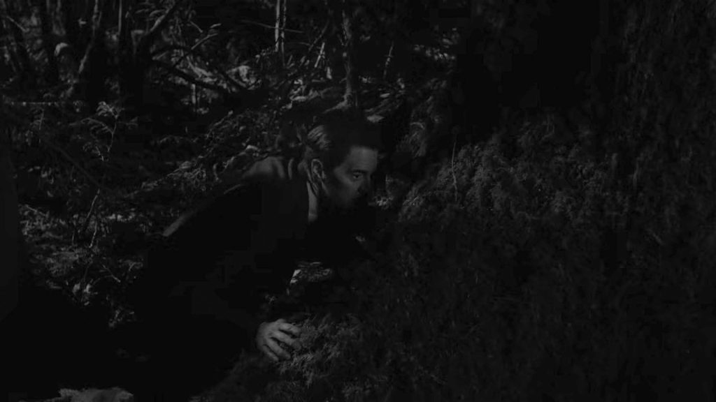 Agent Cooper hiding behind a tree