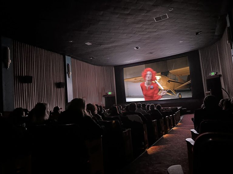 Inside of movie theatre with seats and screen