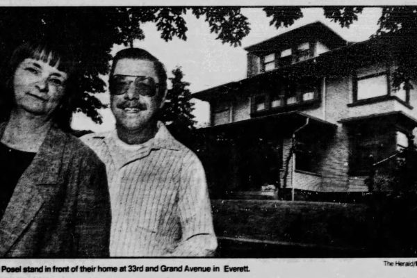 Black and white photo of John and Sue Posel outside their home