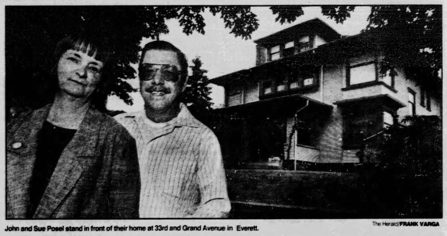 Black and white photo of John and Sue Posel outside their home