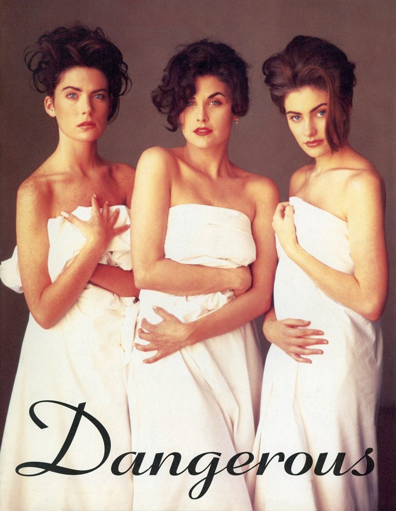 Three women wearing white sheets wrapped around their bodies