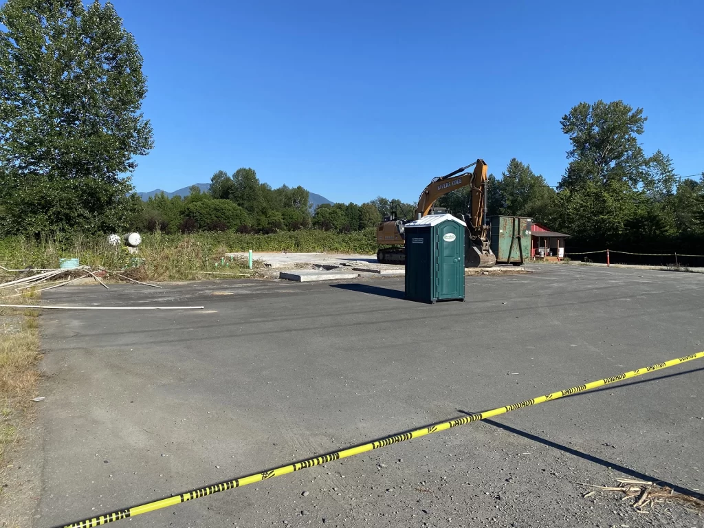 Empty parking lot with port-a-potty and construction equipment