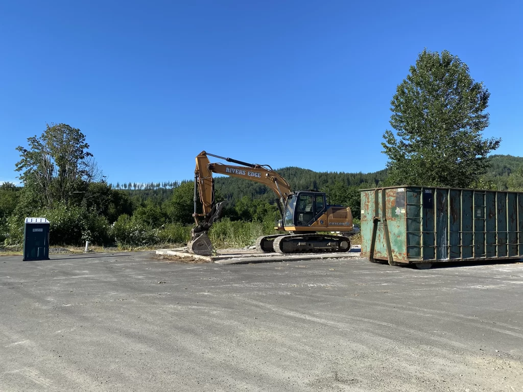 Construction equipment and dumpster by slab