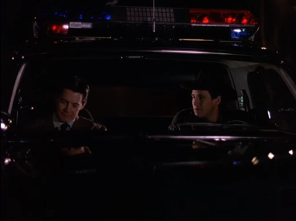 Cooper and Truman in the Sheriff's cruiser