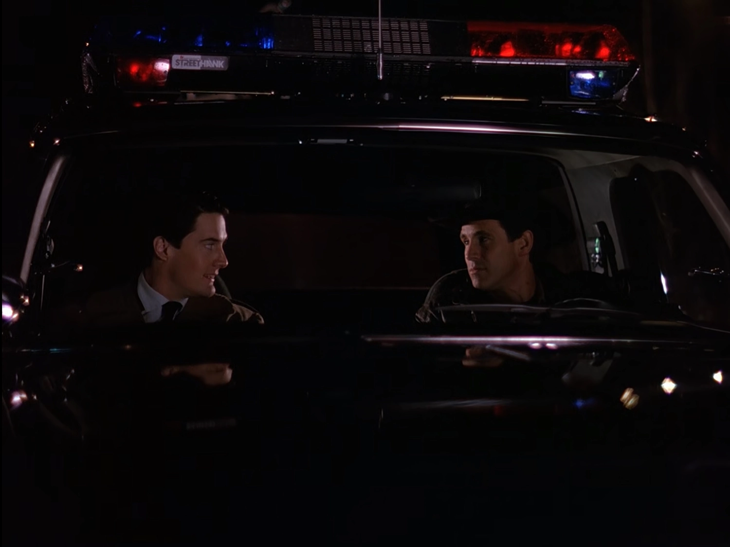 Cooper and Truman in the Sheriff's cruiser