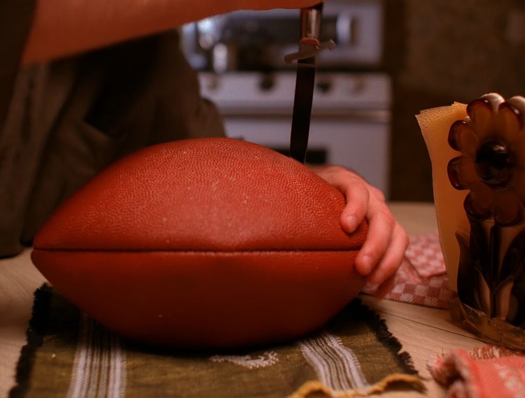 Leo Johnson cutting into a football