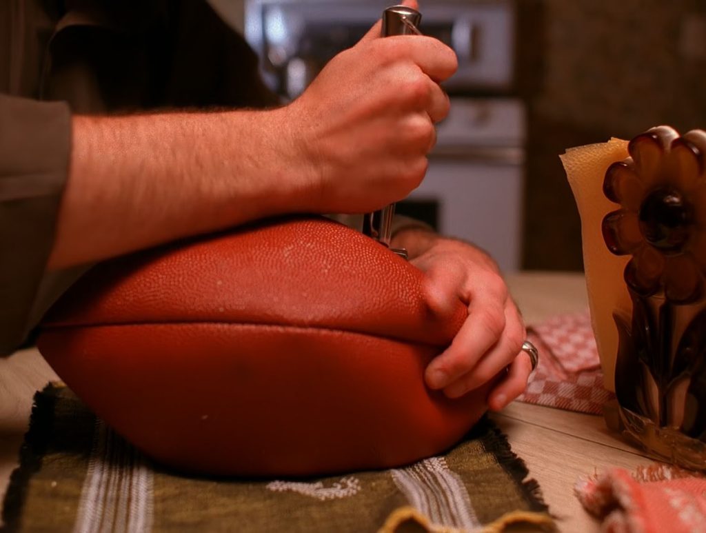 Leo Johnson cutting into a football