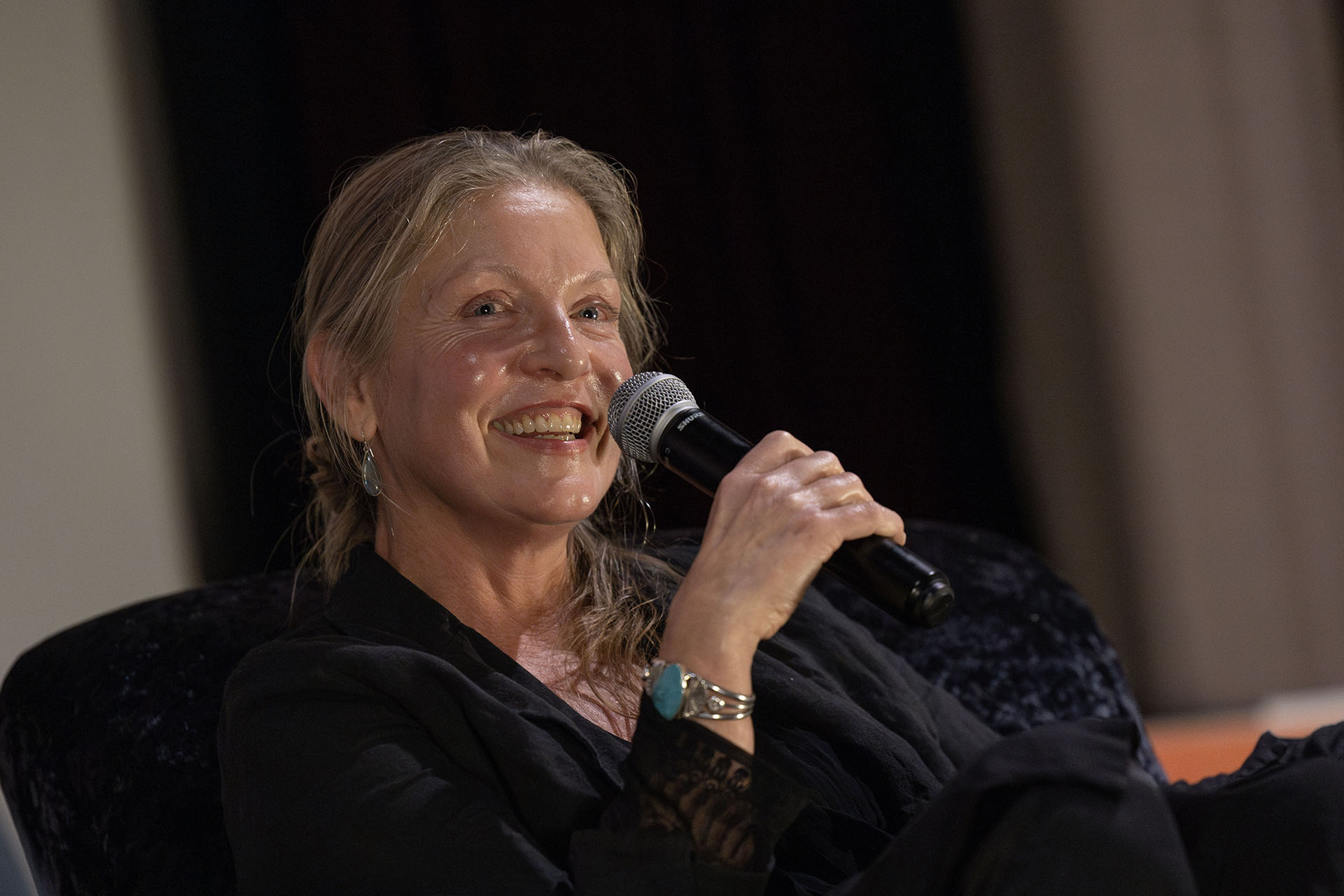 Sheryl Lee holding a microphone and speaking