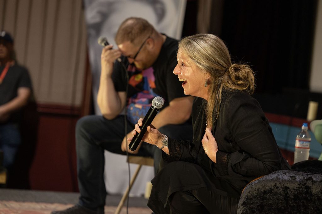 Sheryl Lee holding a microphone and laughing