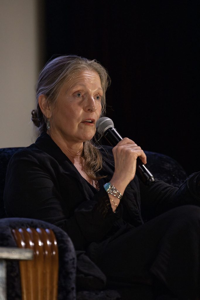 Sheryl Lee holding a microphone and speaking