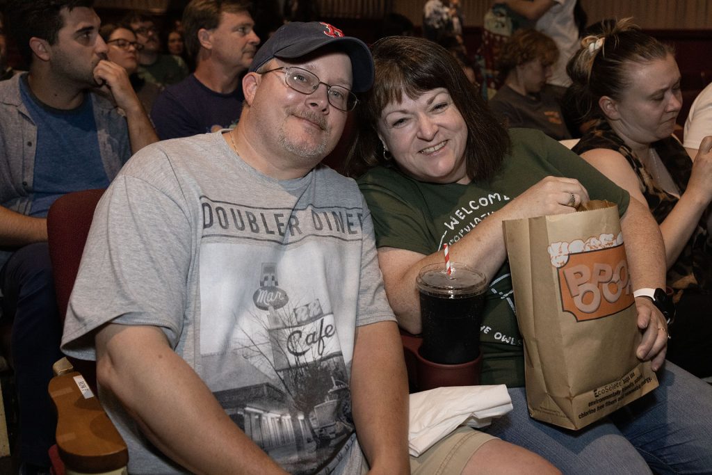 Two people in the theatre with popcorn and drinks