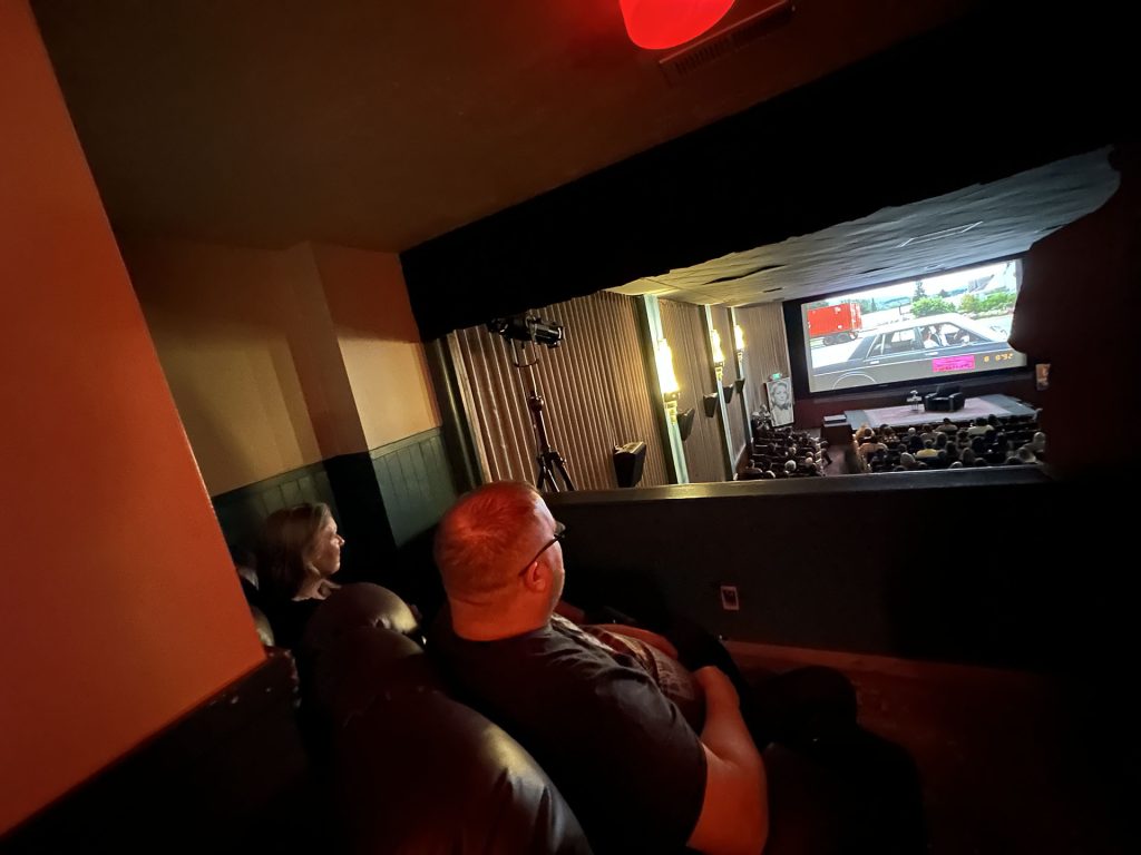 Sheryl Lee and Mike watching the screen from the crying box