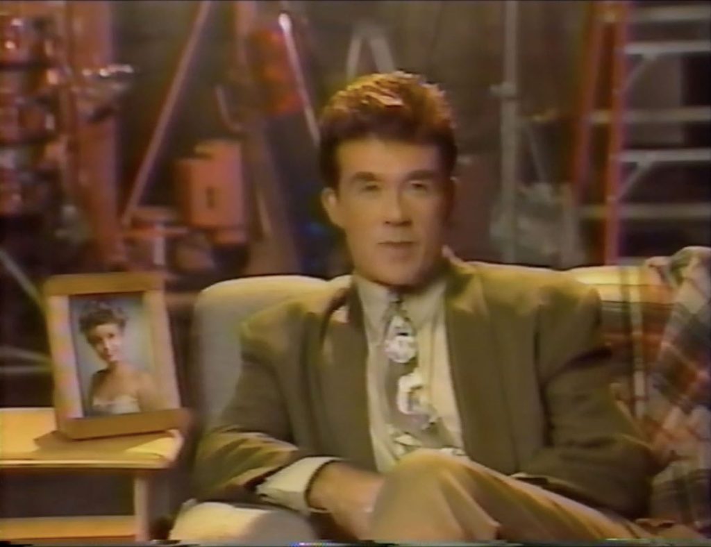 Alan Thicke sitting on a couch